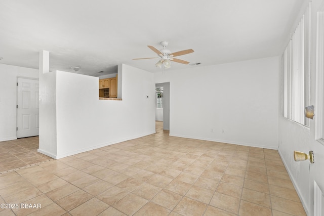 spare room with visible vents, a ceiling fan, and baseboards