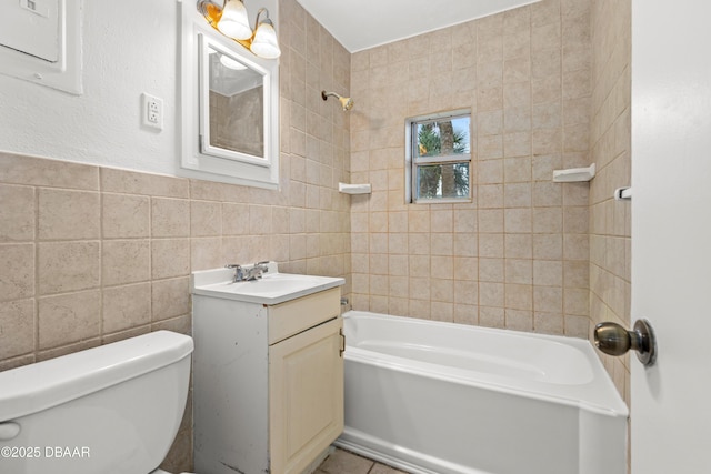 full bathroom featuring toilet, vanity, tile walls, electric panel, and washtub / shower combination