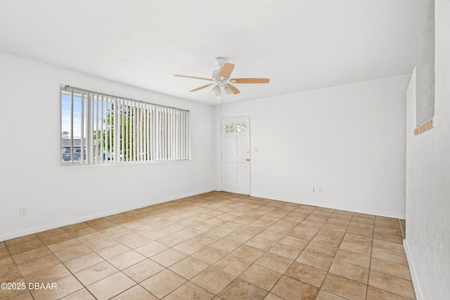 unfurnished room featuring ceiling fan and baseboards