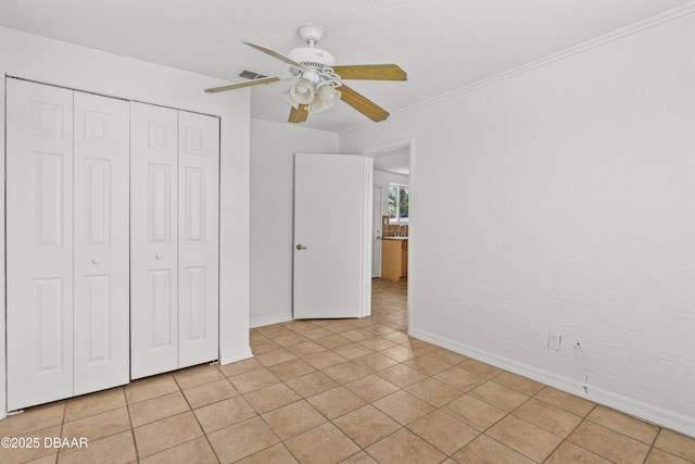 unfurnished bedroom with light tile patterned floors, ceiling fan, baseboards, and a closet