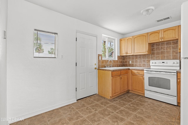 kitchen with white electric range oven, tasteful backsplash, visible vents, light brown cabinetry, and a sink