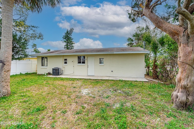 back of property with a yard, stucco siding, a patio area, fence, and cooling unit