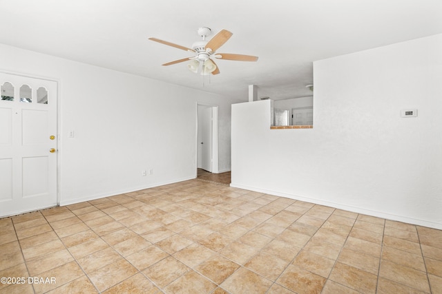 unfurnished room featuring ceiling fan and baseboards