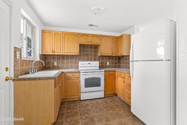 kitchen with white appliances, light countertops, a sink, and decorative backsplash