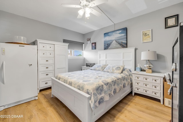 721 S Beach St Unit 215A, Daytona Beach, FL 32114 - bedroom with freestanding refrigerator, light wood finished floors, and ceiling fan