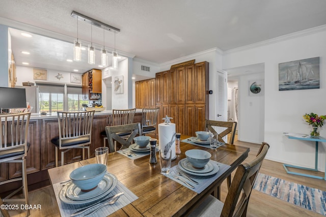 721 S Beach St Unit 215A, Daytona Beach, FL 32114 - dining area with crown molding and light wood-style floors