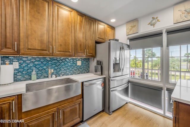 721 S Beach St Unit 215A, Daytona Beach, FL 32114 - kitchen with appliances with stainless steel finishes, a sink, light countertops, light wood-style flooring, and decorative backsplash