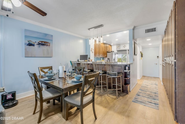 721 S Beach St Unit 215A, Daytona Beach, FL 32114 - dining room with light wood-style floors, crown molding, and ceiling fan