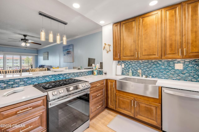 721 S Beach St Unit 215A, Daytona Beach, FL 32114 - kitchen with appliances with stainless steel finishes, a sink, ornamental molding, brown cabinetry, and a ceiling fan
