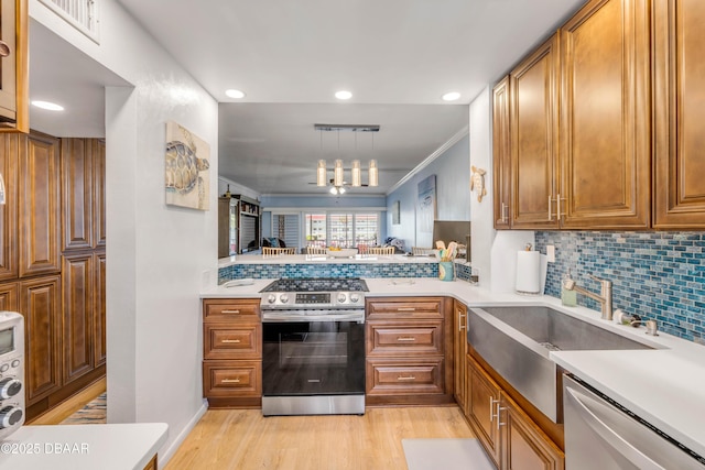 721 S Beach St Unit 215A, Daytona Beach, FL 32114 - kitchen with appliances with stainless steel finishes, light countertops, light wood finished floors, brown cabinets, and recessed lighting