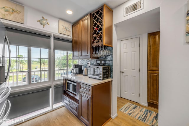 721 S Beach St Unit 215A, Daytona Beach, FL 32114 - kitchen featuring appliances with stainless steel finishes, light wood-style flooring, backsplash, light countertops, and recessed lighting