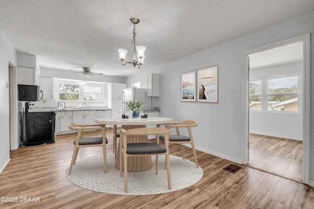 dining space featuring light wood-type flooring, a wealth of natural light, and baseboards