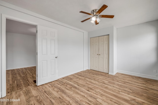 unfurnished bedroom featuring light wood finished floors, baseboards, a ceiling fan, and a closet