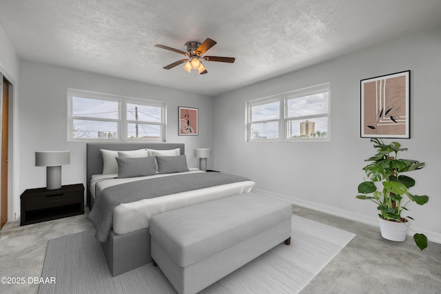 bedroom with light carpet, multiple windows, and a textured ceiling