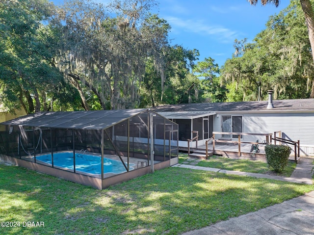 view of swimming pool with a sunroom, a deck, glass enclosure, and a lawn