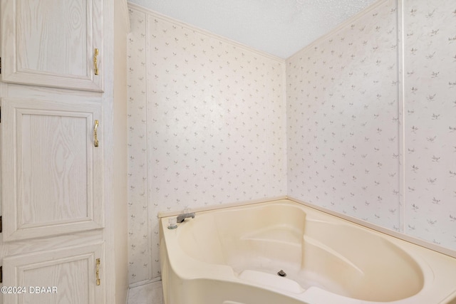 bathroom featuring a bathing tub, crown molding, and a textured ceiling