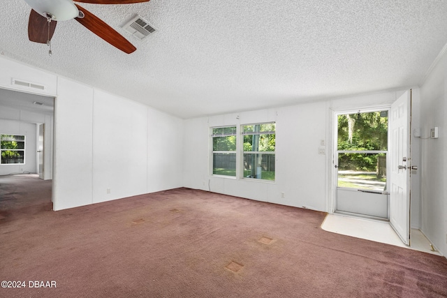 unfurnished room with ceiling fan, a wealth of natural light, a textured ceiling, and carpet flooring