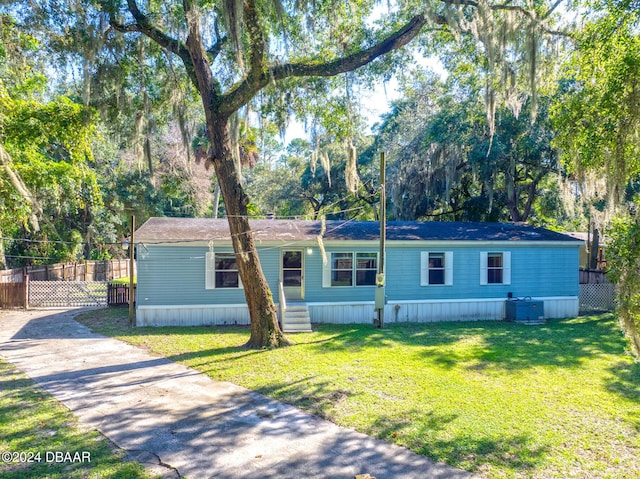 view of front of home with a front lawn and central air condition unit