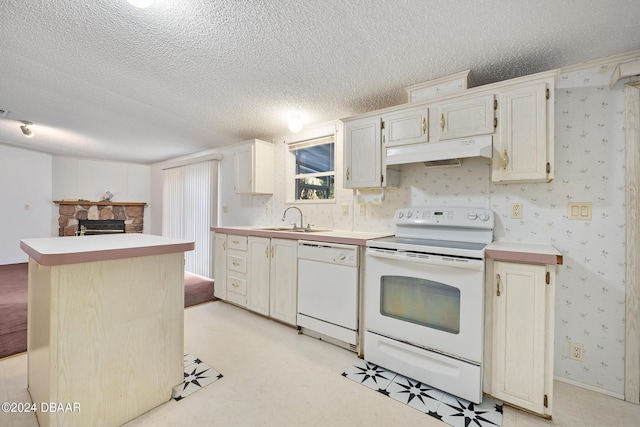 kitchen with a kitchen island, a fireplace, sink, white appliances, and a textured ceiling