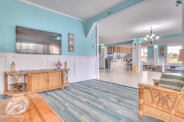 carpeted living room with a textured ceiling, a notable chandelier, and ornamental molding