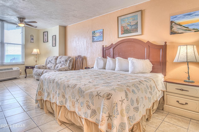 bedroom featuring a wall mounted air conditioner, a textured ceiling, ceiling fan, and light tile patterned floors