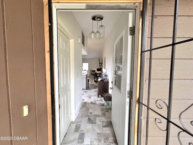 hall featuring stone finish flooring