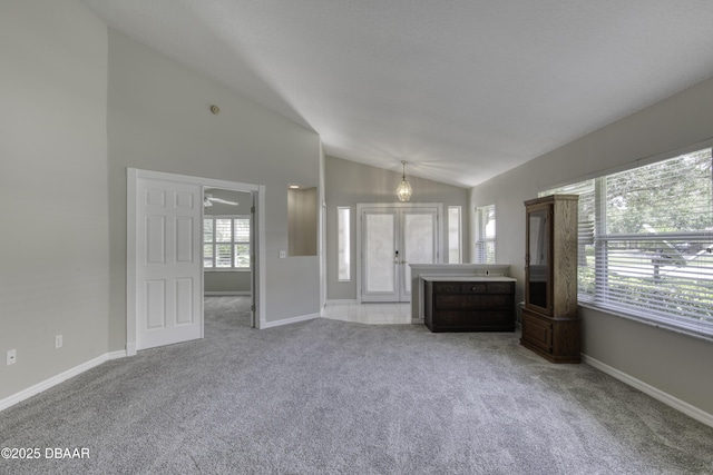 438 Harbour Town Ln, Ormond Beach, FL 32174 - unfurnished living room with lofted ceiling, carpet flooring, and baseboards
