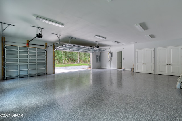 garage with electric panel and a garage door opener