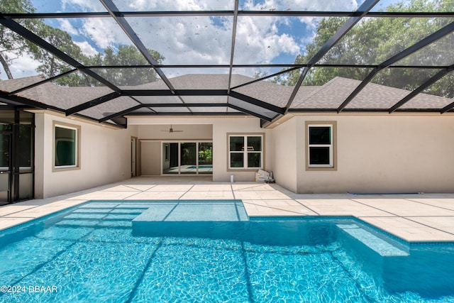 view of swimming pool with ceiling fan, glass enclosure, and a patio area