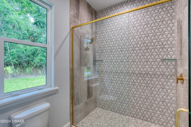 bathroom with toilet and a shower with door