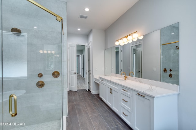 bathroom with a shower with shower door and vanity