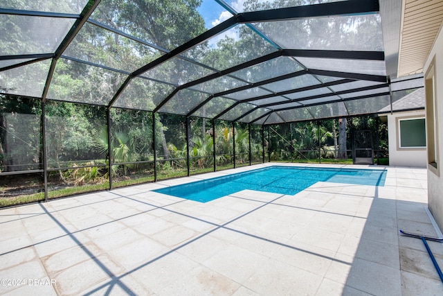 view of swimming pool with a patio and a lanai