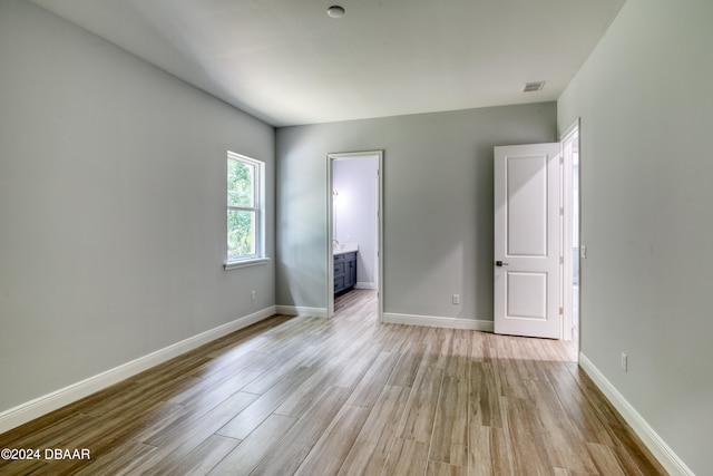 interior space with ensuite bathroom and light hardwood / wood-style flooring