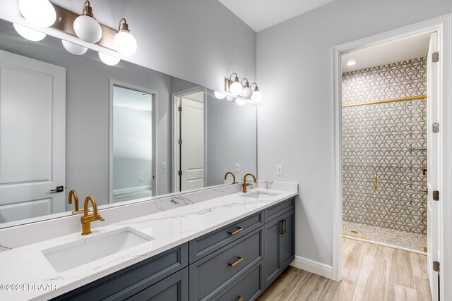 bathroom with hardwood / wood-style floors, vanity, and a shower