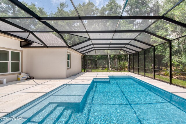 view of swimming pool with a patio and glass enclosure