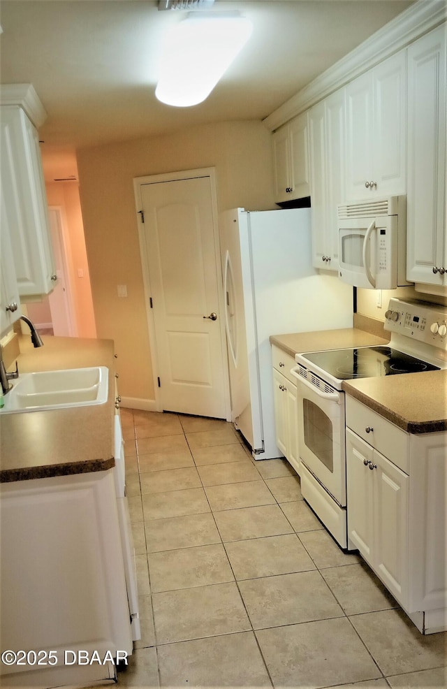 kitchen featuring white cabinetry, white appliances, light tile patterned flooring, and sink