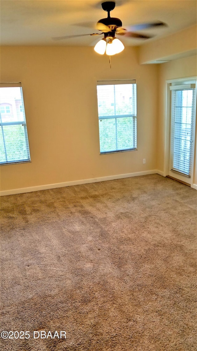 carpeted empty room featuring ceiling fan and plenty of natural light