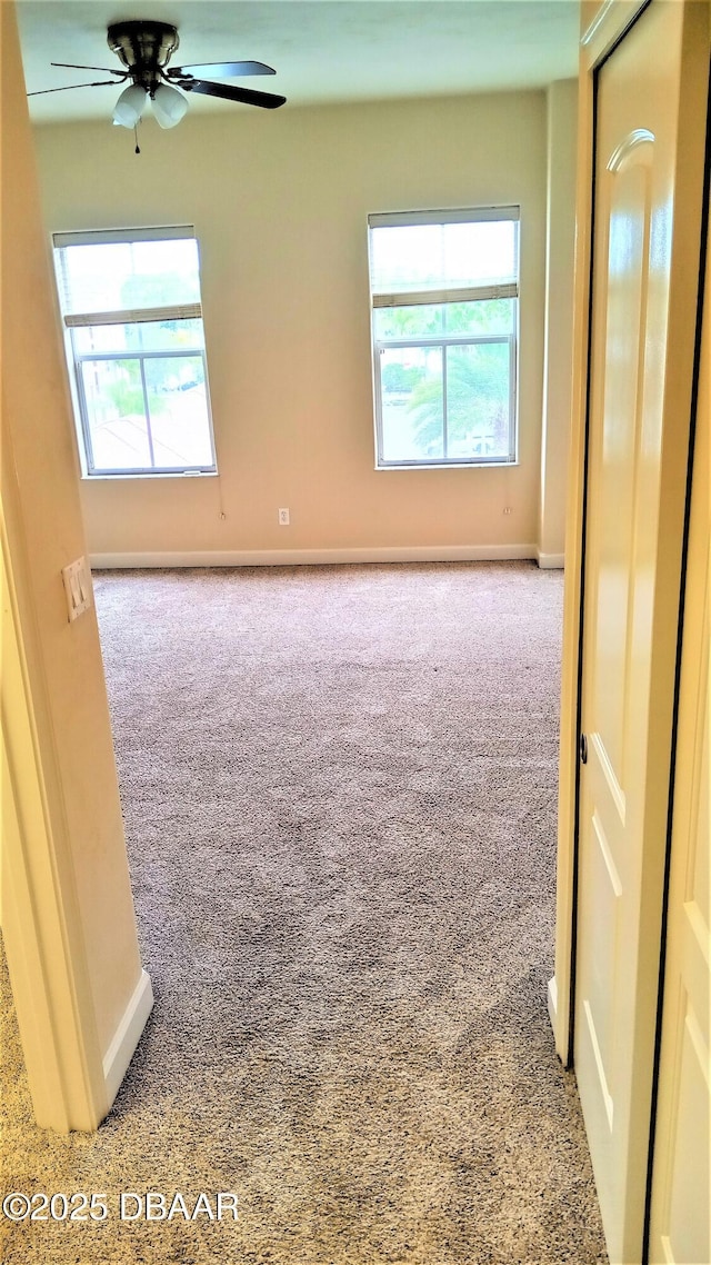 spare room featuring plenty of natural light, light colored carpet, and ceiling fan