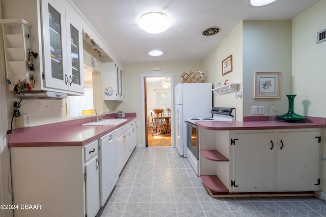 kitchen with white appliances, white cabinetry, and sink