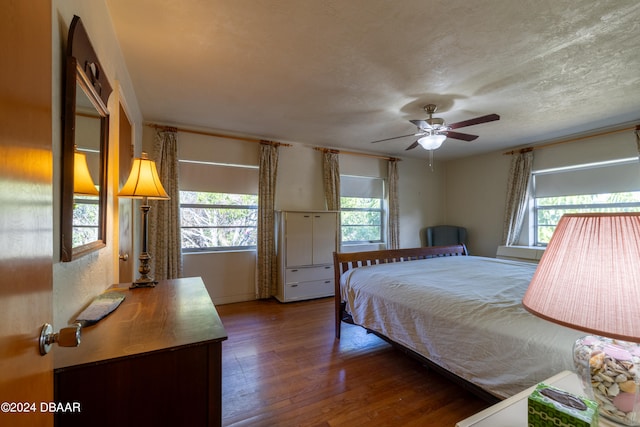 bedroom with a textured ceiling, hardwood / wood-style floors, and ceiling fan