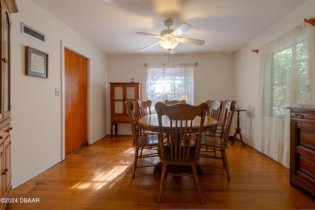 dining room with light wood-type flooring, a wealth of natural light, and ceiling fan