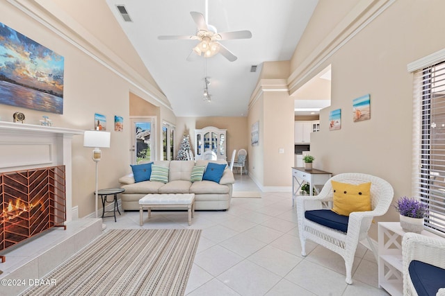 living room featuring a fireplace, light tile patterned floors, high vaulted ceiling, and ceiling fan