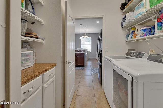 clothes washing area with a chandelier, light tile patterned floors, and independent washer and dryer