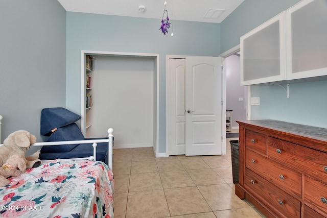 bedroom featuring light tile patterned floors and a closet