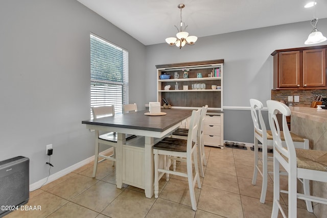 dining area with light tile patterned flooring and an inviting chandelier