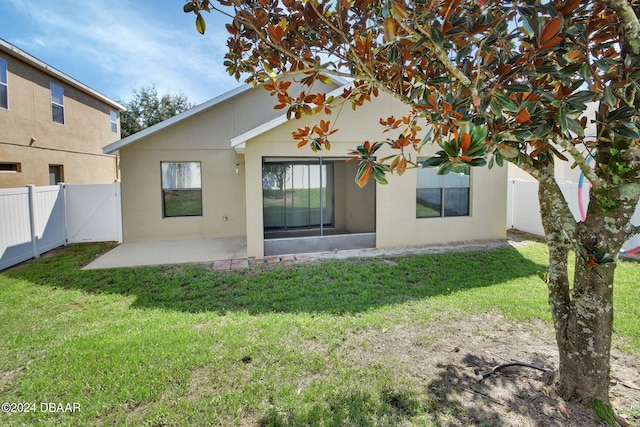 rear view of house with a patio and a yard