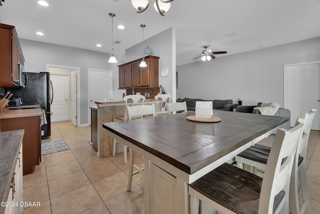 kitchen with ceiling fan with notable chandelier, light tile patterned floors, decorative light fixtures, and tasteful backsplash