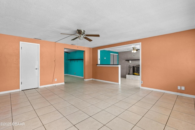 1572 Primrose Ln, Daytona Beach, FL 32117 - spare room featuring a ceiling fan, a textured ceiling, light tile patterned floors, and baseboards