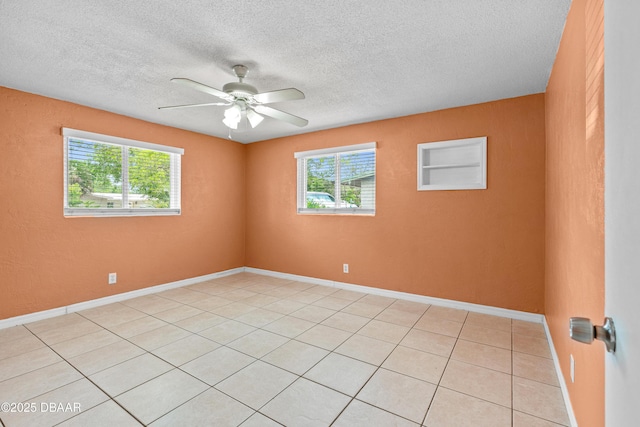 1572 Primrose Ln, Daytona Beach, FL 32117 - unfurnished room with healthy amount of natural light, ceiling fan, a textured ceiling, light tile patterned flooring, and baseboards