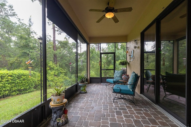 unfurnished sunroom with ceiling fan